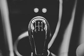 Gear shift knob of a manual transmission car displaying gear positions in an H-pattern.