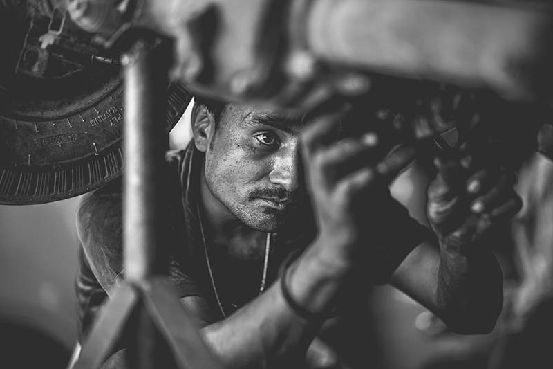 Mechanic performing maintenance work under a vehicle with professional tools