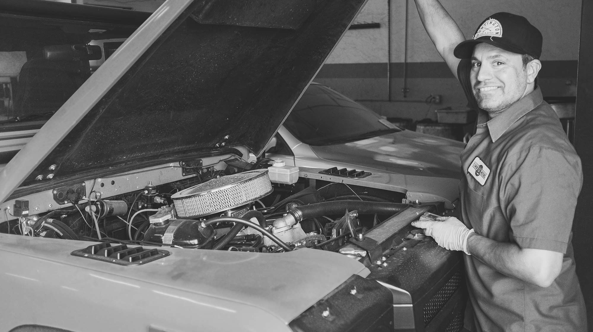 Professional mechanic working on a car transmission in a well-equipped workshop